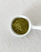 Teappo Four Springs Powder in a clear container with a scoop, showcasing its natural blend of herbal ingredients.