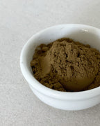 Teappo Iron Goddess Powder in a clear container with a scoop, showcasing the product's fine texture and packaging design.