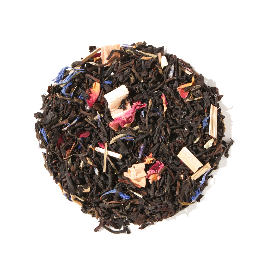 Plum Deluxe Kitchen Table Blend Black-Green Tea (with Secret Citrus Mix) in a circular packaging with citrus and floral imagery.