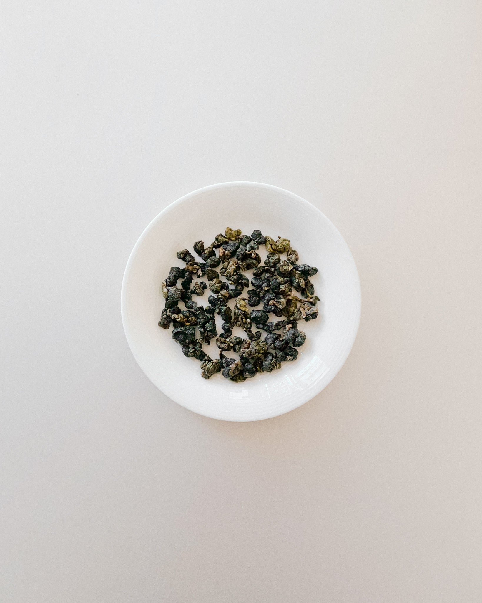 Teappo Milk Oolong tea leaves displayed in a clear tea cup, showcasing their color and texture