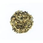 Mystique Mélange by Nepal Tea, a loose leaf tea blend displayed in a natural setting with a focus on the tea's textures.