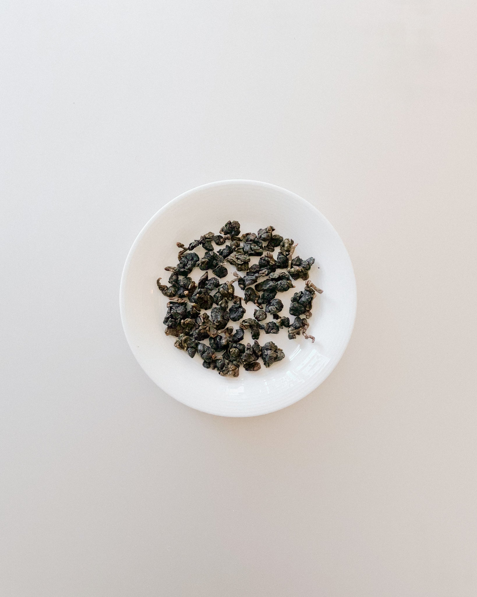 Teappo Orchid Oolong tea leaves displayed in a loose form, showcasing their unique color and texture.
