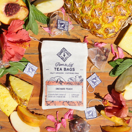 Piper and Leaf Orchard Peach 9ct Tea Bags in Muslin, featuring pyramid sachets of peach tea with tropical floral ingredients.