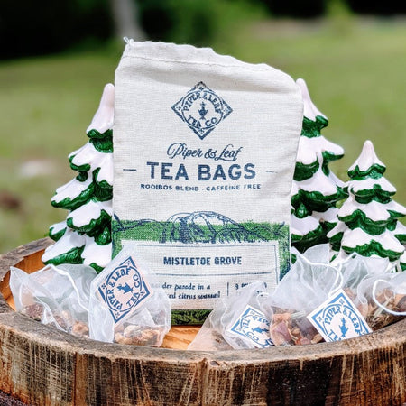 Piper and Leaf Mistletoe Grove 9ct Tea Bags in Muslin, showing hand-printed muslin bags with pyramid sachets of festive tea.