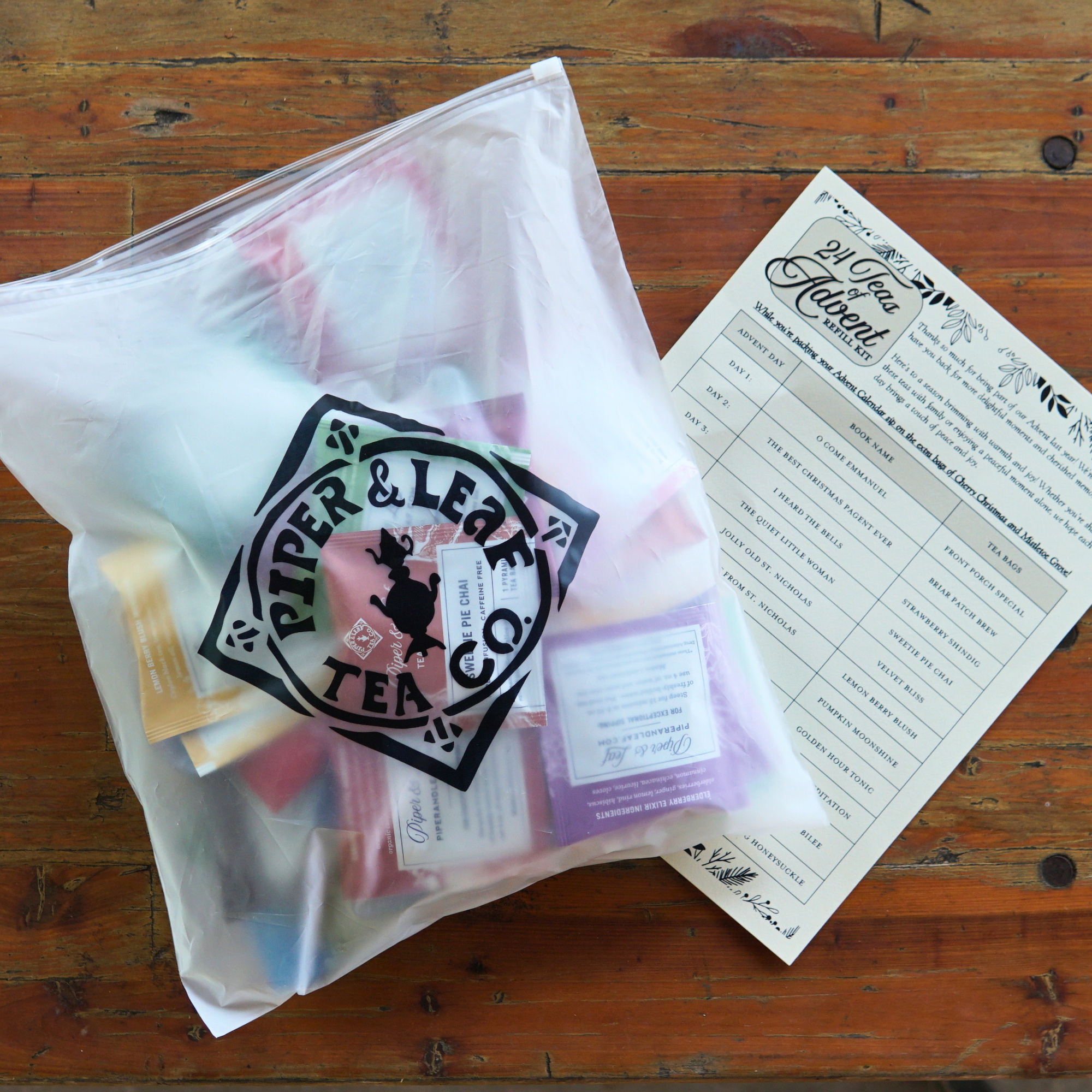Piper and Leaf Advent Calendar Refill Kit featuring 48 artisan tea bags, packing guide, and extra bags of Cherry Christmas and Mistletoe Grove.