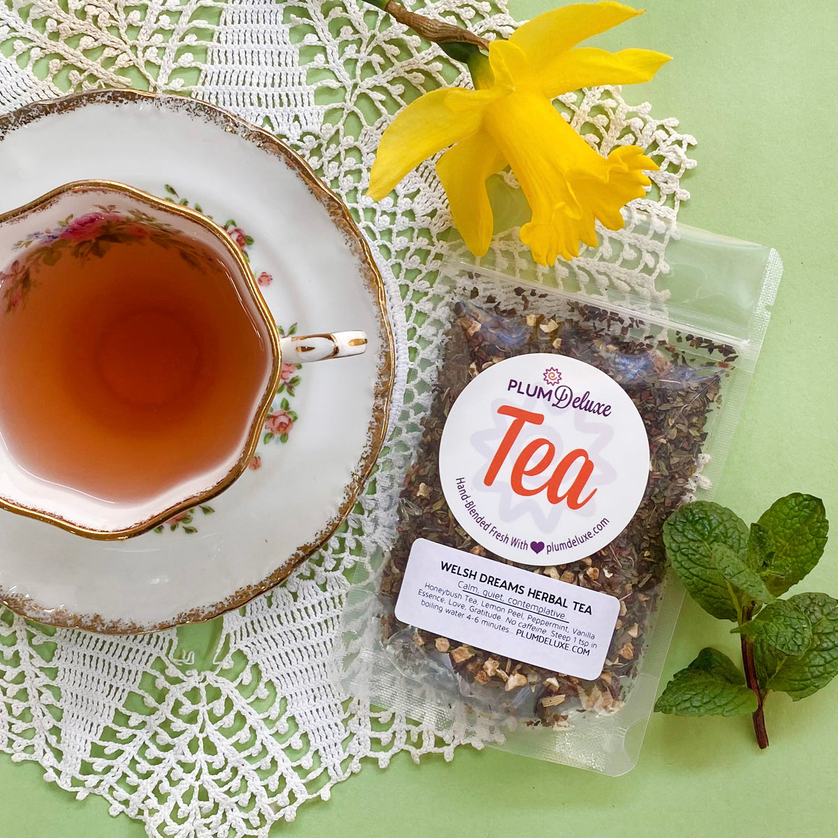 Plum Deluxe Welsh Dreams Herbal Tea (Vanilla - Lemon - Mint) in a tea cup with a soft background