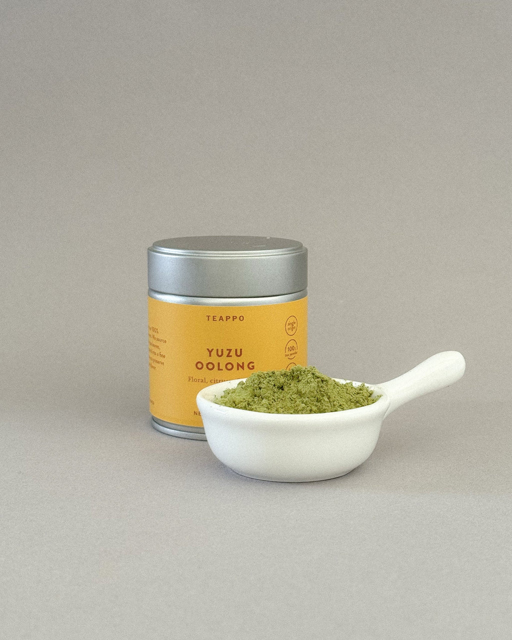Teappo Yuzu Oolong Powder in a package, featuring a yellow label with brand logo and product details, shown on a plain background.