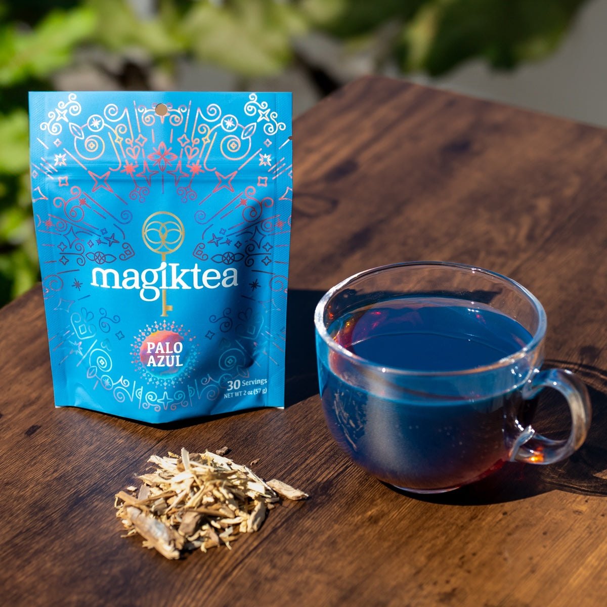 Blue magiktea package with a cup of tea on a wooden table