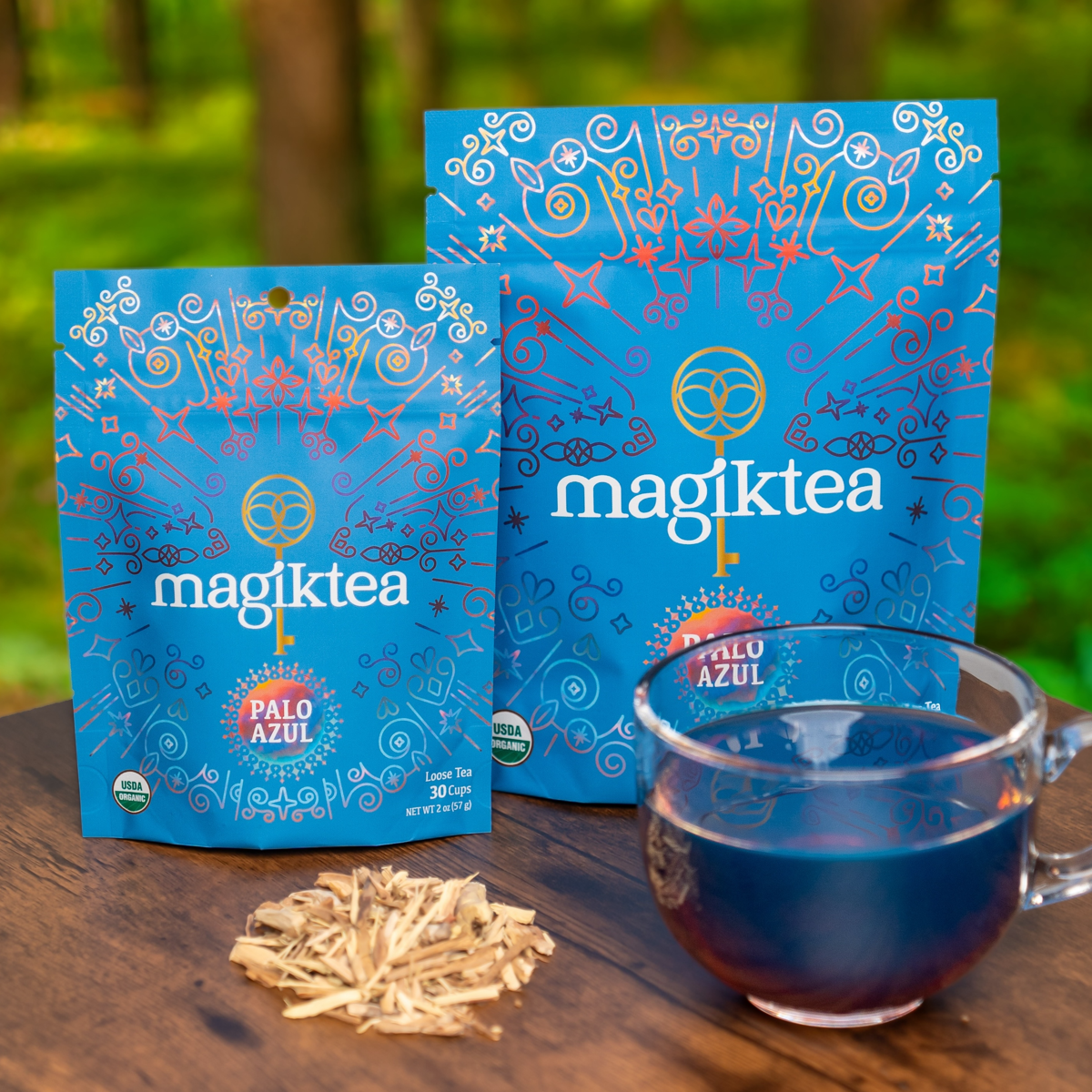 magiktea Palo Azul tea packages with a cup of tea on a wooden surface