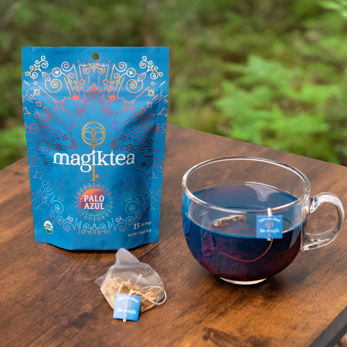 magiktea Palo Azul tea package with a cup of tea on a wooden surface