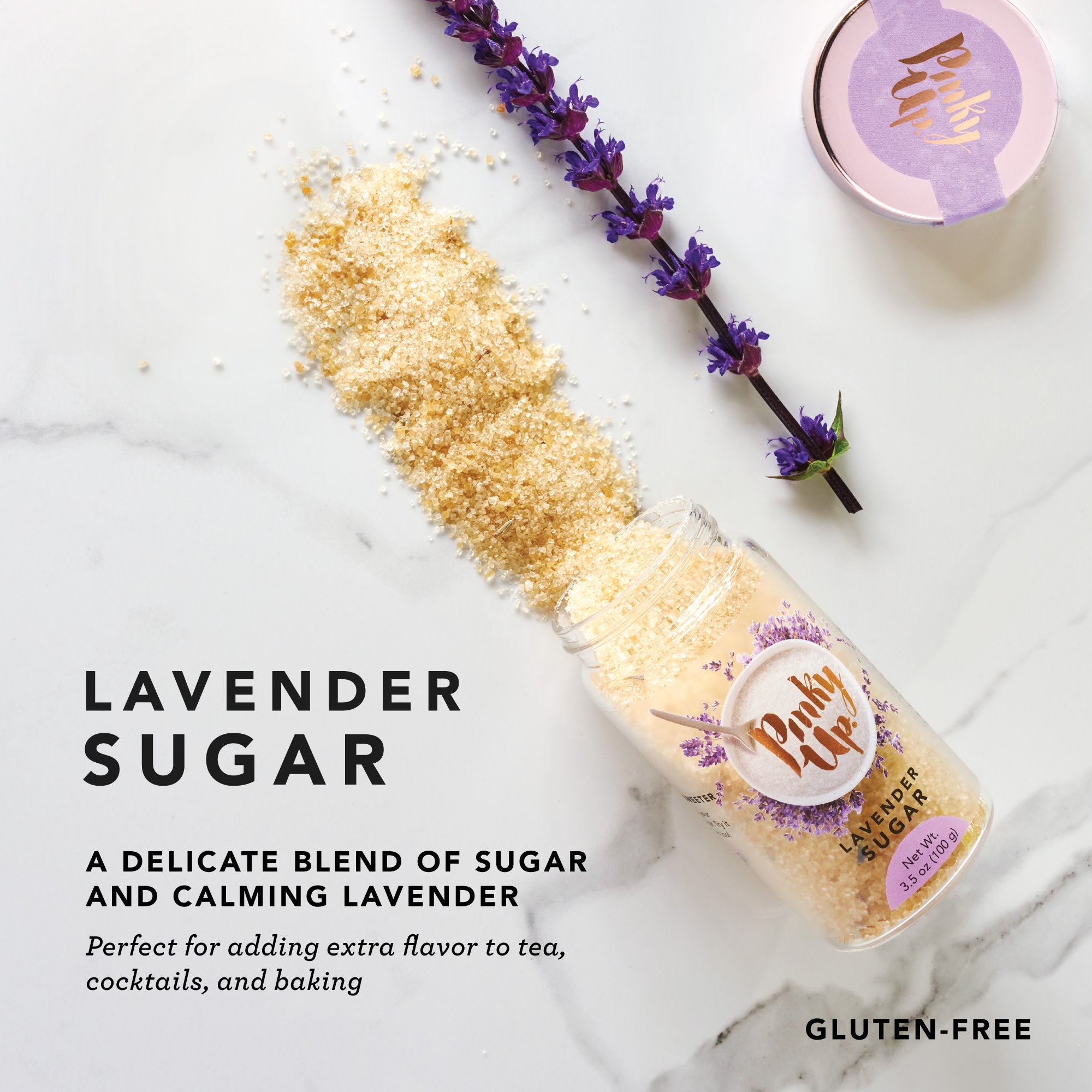 Pinky Up Lavender Sugar in a clear container with lavender flowers, ideal for sweetening beverages and baked goods.