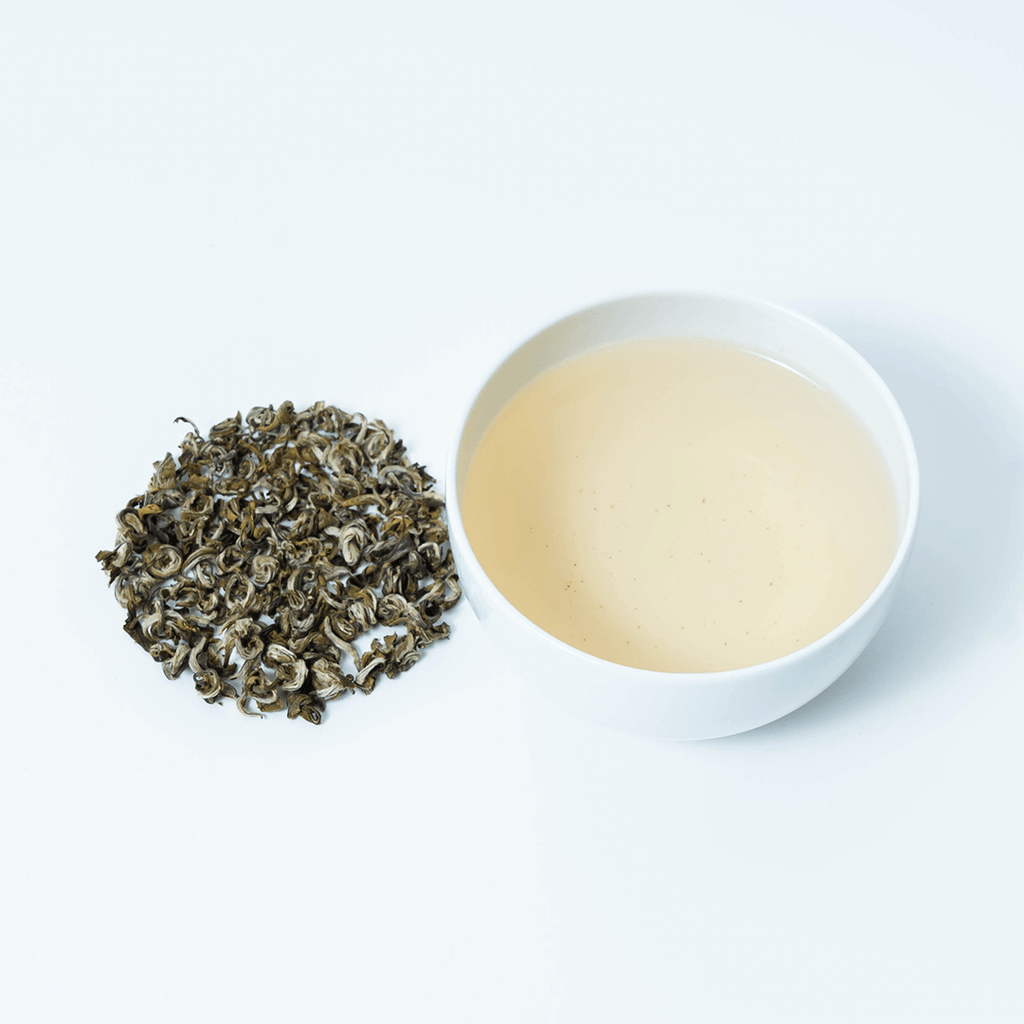 Farmers' Green tea by Nepal Tea, showing loose leaf tea leaves in a small bowl on a wooden surface