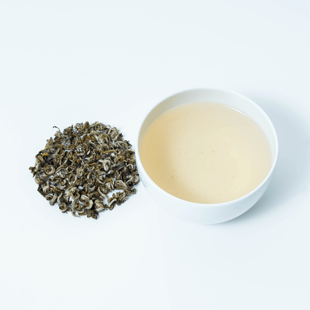 Farmers' Green tea by Nepal Tea, showing loose leaf tea leaves in a small bowl on a wooden surface