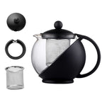 Black teapot with clear glass body and metal mesh filter on a white background