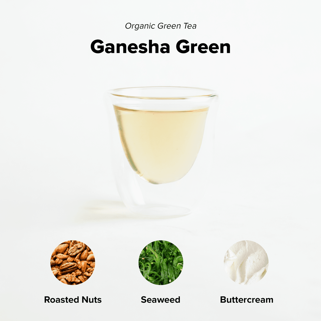 Ganesha Green - Organic Green Tea by Nepal Tea in a green packaging with tea leaves and a cup in the background.
