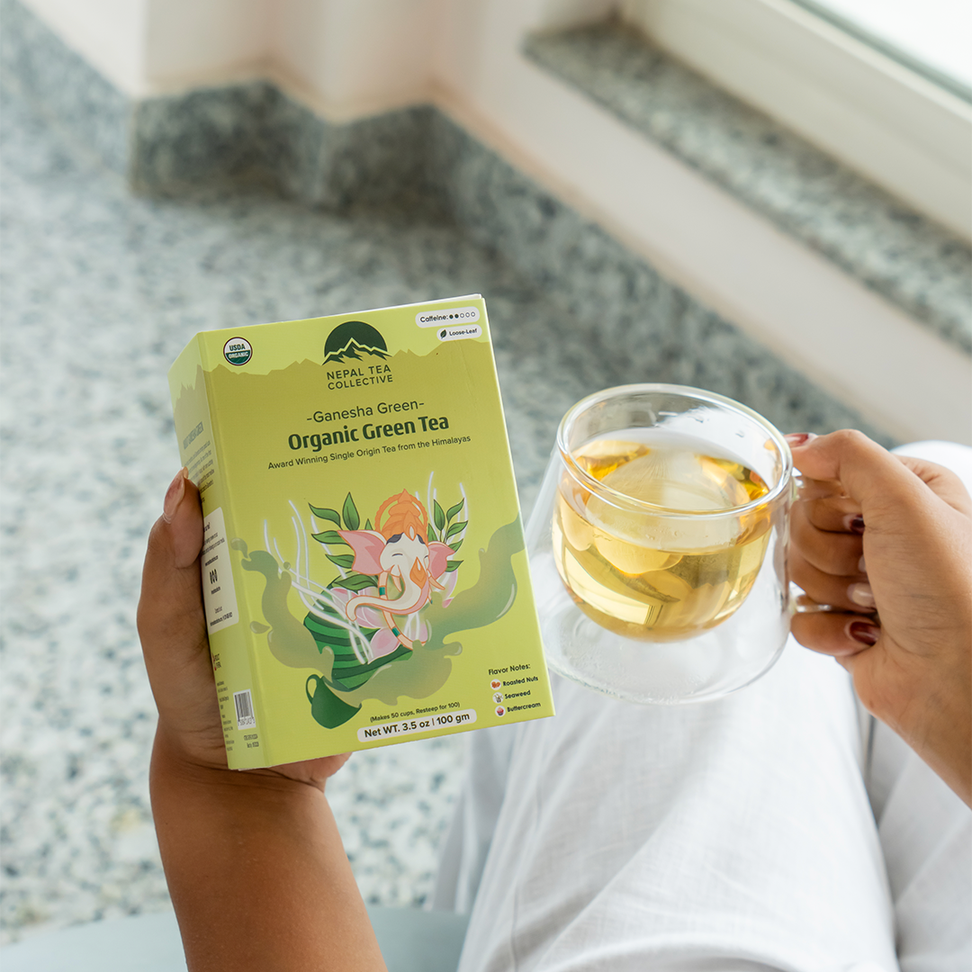 Ganesha Green - Organic Green Tea by Nepal Tea in a package, featuring green tea leaves and branding elements.
