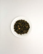 Teappo Jasmine Oolong tea leaves displayed in a clear container, showcasing the product's color and texture.