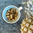 Plum Deluxe Pineapple Pop Herbal Tea in a square packaging with a pineapple design, displayed on a flat surface.