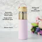 Pinky Up Dana Glass Travel Mug in Lavender featuring a clear glass design and a lavender silicone sleeve for insulation.