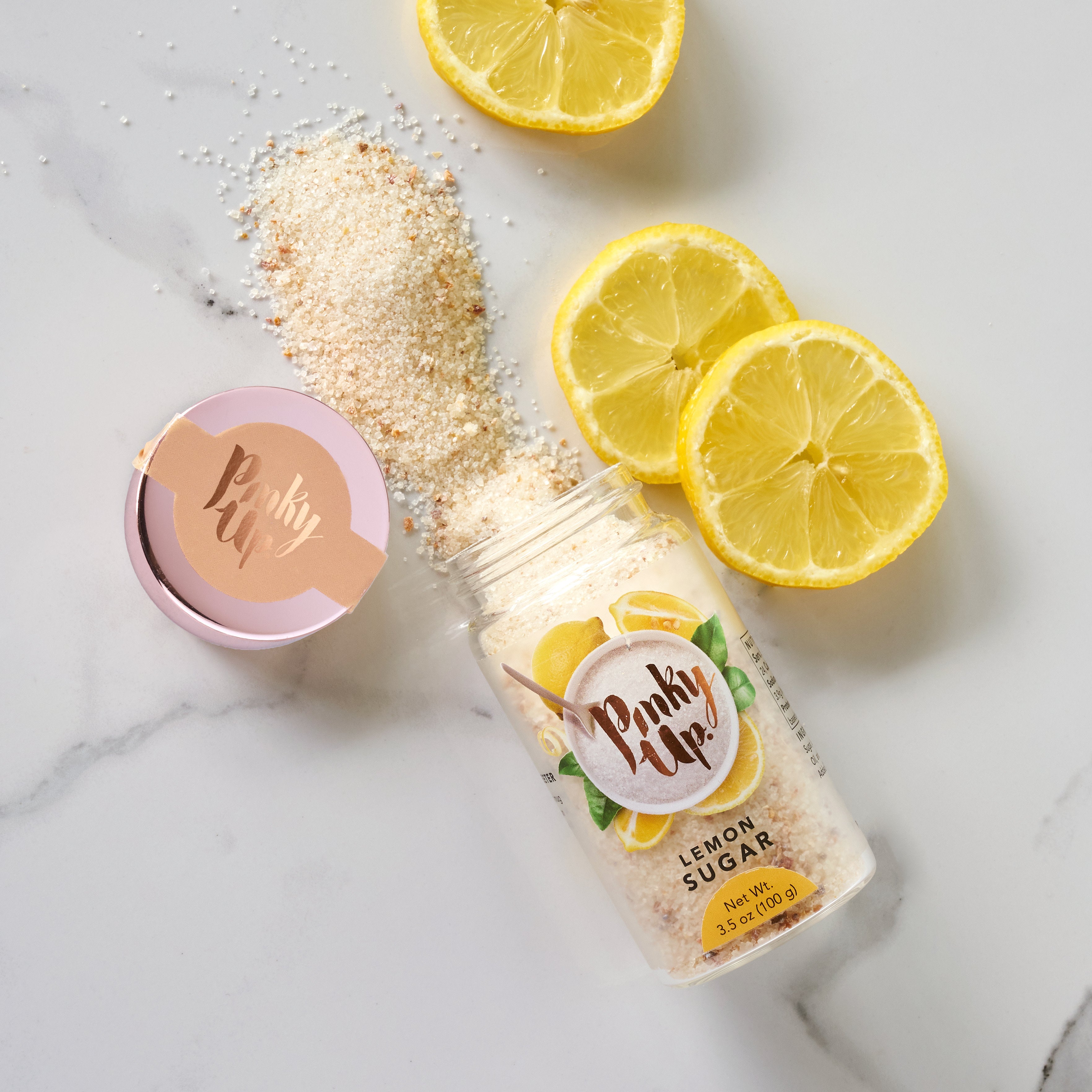 Pinky Up Lemon Sugar in a clear container, featuring a yellow, granular sugar blend for tea and beverage sweetening.